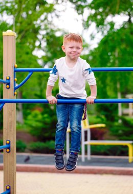 Küçük çocuk oyun alanında oynuyor..