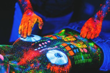 Girl painted as DJ deck and man playing on disks