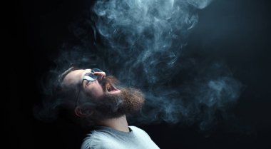 Kavram. Duman kafa adam sardı. Duman ile sakallı, şık bir adam portresi. İkinci el duman.