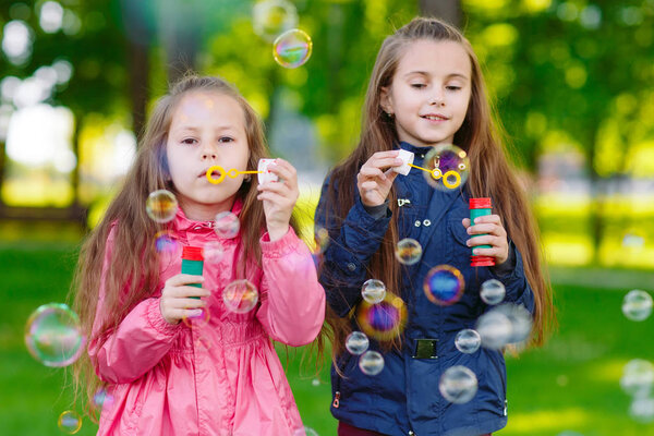 Girls play with soap bubbles.