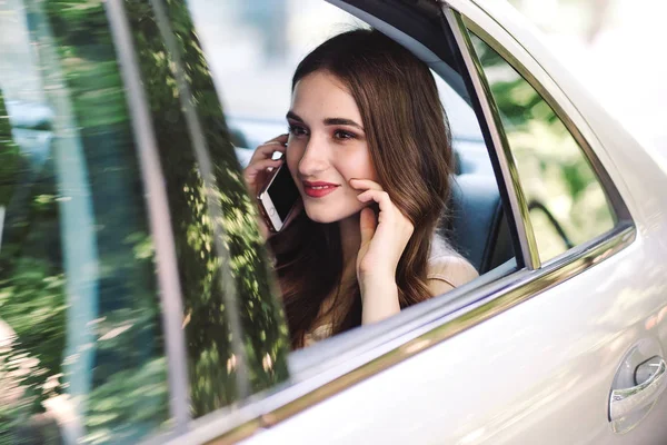 Una Joven Está Sentada Asiento Trasero Coche Está Hablando Por — Foto de Stock