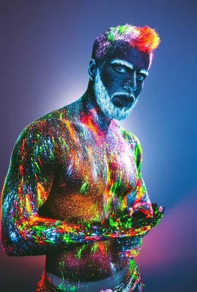 Concept. A bearded man in Barbershop. A stylish bearded man is trimmed  in Barber Shop. The man is decorated in ultraviolet powder.