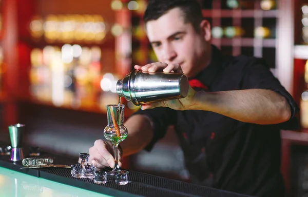 Bartender pouring fresh cocktail in fancy glass