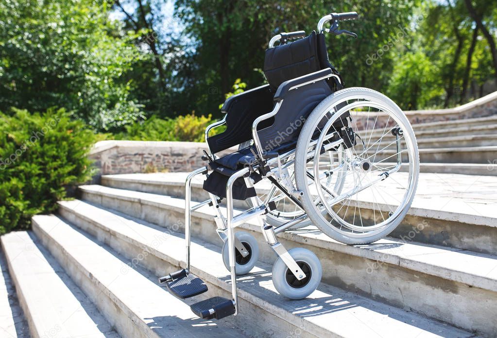 empty metal wheelchair on steps outdoors