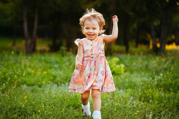 Happy cute little girl running on the grass in the park. Happiness — Stock Photo, Image