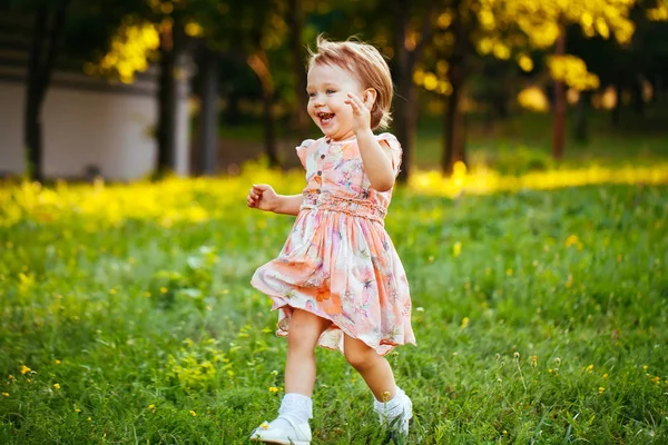 Joyeux petite fille mignonne courant sur l'herbe dans le parc. Le bonheur — Photo