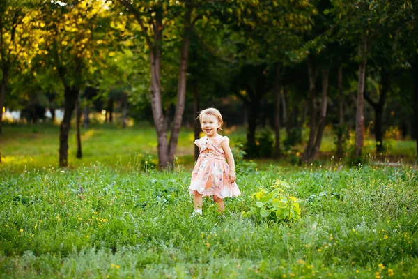 Joyeux petite fille mignonne courant sur l'herbe dans le parc. Le bonheur — Photo