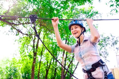 Yüksek telli parka tırmanma macerası - insanlar dağ kaskı ve güvenlik ekipmanları ile rotalarında