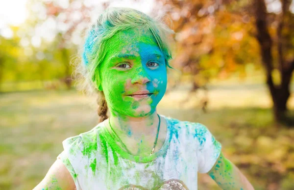 Portrait of a cute girl painted in the colors of Holi festival. — Stock Photo, Image