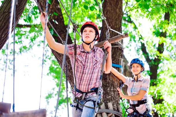 Aventure escalade haut fil parc - les gens sur le cours en casque de montagne et de l'équipement de sécurité — Photo