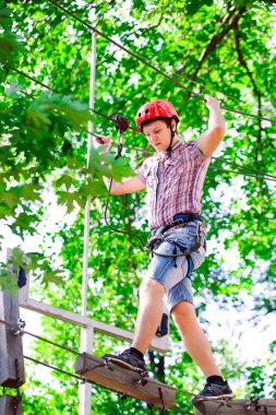 Yüksek telli parka tırmanma macerası - insanlar dağ kaskı ve güvenlik ekipmanları ile rotalarında