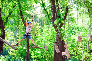 Yüksek telli parka tırmanma macerası - insanlar dağ kaskı ve güvenlik ekipmanları ile rotalarında