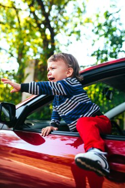 Arabada ağlayan bir çocuk. Çocuk ağlıyor ve maniche çıkmak istiyor