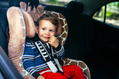 Bir güvenlik oto koltuğunda sevimli erkek bebek.