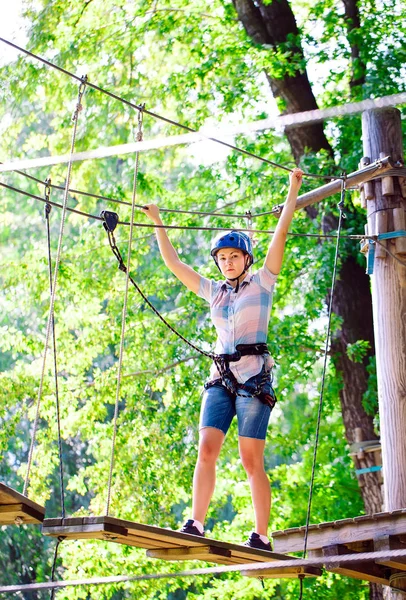 Aventura escalada alto fio parque - pessoas em curso em capacete de montanha e equipamentos de segurança — Fotografia de Stock