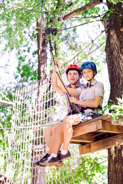 Aventura escalada parque de alambre de alta - personas en curso en casco de montaña y equipo de seguridad — Foto de Stock