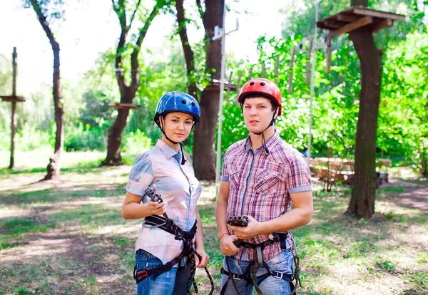 Aventure escalade haut fil parc - les gens sur le cours en casque de montagne et de l'équipement de sécurité — Photo