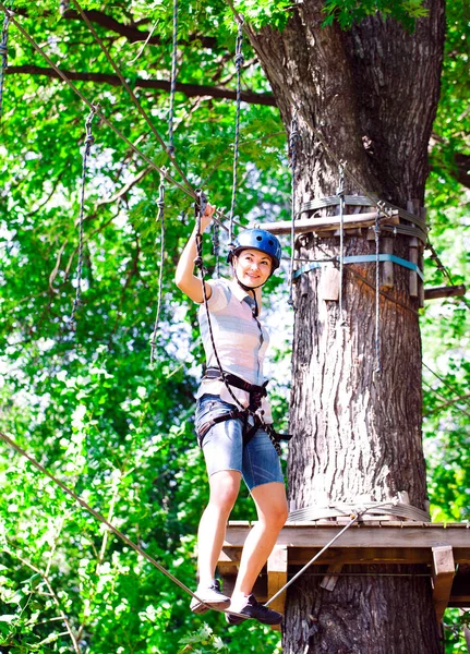 Aventura escalada parque de alambre de alta - personas en curso en casco de montaña y equipo de seguridad — Foto de Stock