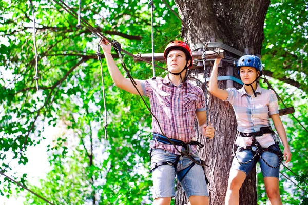 Aventure escalade haut fil parc - les gens sur le cours en casque de montagne et de l'équipement de sécurité — Photo