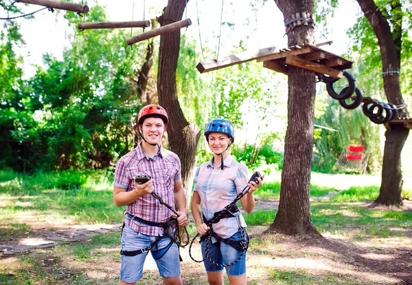 Aventura escalada parque de alambre de alta - personas en curso en casco de montaña y equipo de seguridad — Foto de Stock