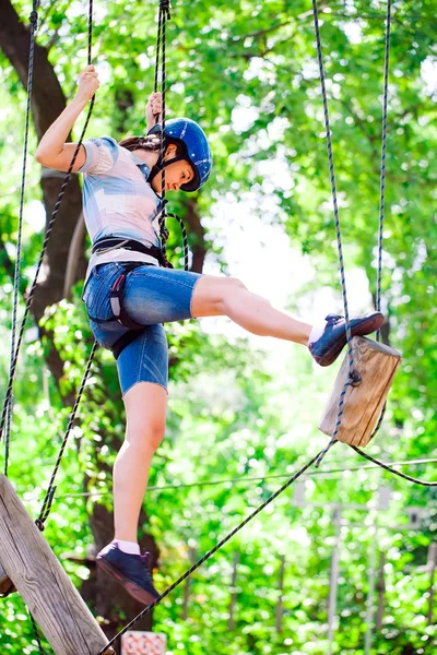 Aventura escalada alto fio parque - pessoas em curso em capacete de montanha e equipamentos de segurança — Fotografia de Stock