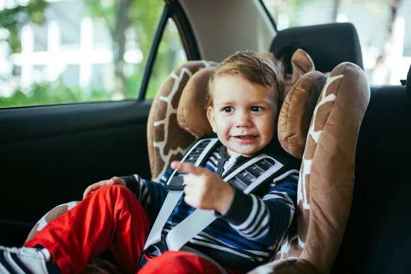 Adorable bebé en un asiento de seguridad . — Foto de Stock