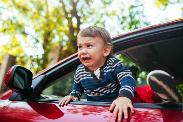 Weinender kleiner Junge im Auto. der Junge weint und will aus dem Manie herauskommen — Stockfoto