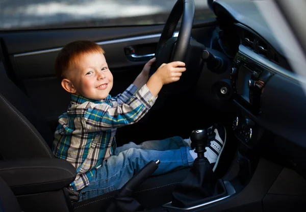 Lindo niño sonriendo y conduciendo coche padres — Foto de Stock