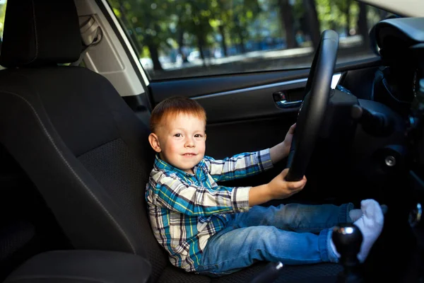 Cute little boy smiling and driving fathers car — Stock Photo, Image