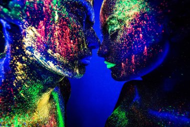 İnsanlar renkli floresan tozudur. Diskoda dans eden bir çift aşık.
