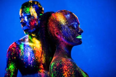 İnsanlar renkli floresan tozudur. Diskoda dans eden bir çift aşık.