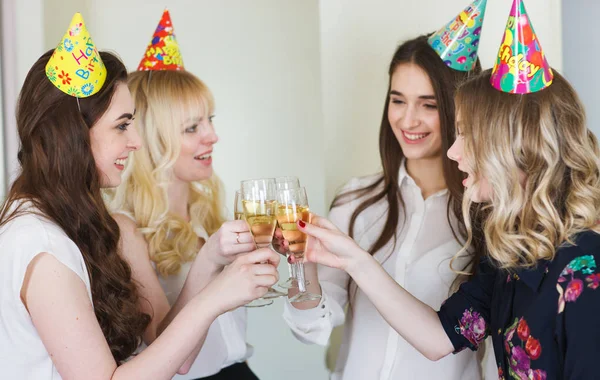 Meisjes feliciteren vriend op haar verjaardag met glazen champagne in de hand. — Stockfoto