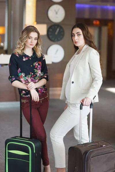 Встреча на ресепшене отеля, девушки с чемоданами в вестибюле отеля — стоковое фото