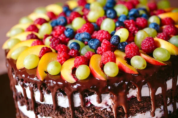 Fruit, cake naakt. zelfgemaakte taart met frambozen, druiven en perzik schijfjes. — Stockfoto