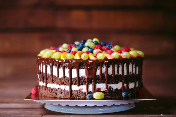 Fruit, cake naakt. zelfgemaakte taart met frambozen, druiven en perzik schijfjes. — Stockfoto