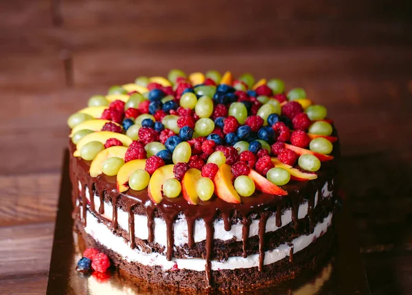 Fruit, cake naakt. zelfgemaakte taart met frambozen, druiven en perzik schijfjes. — Stockfoto