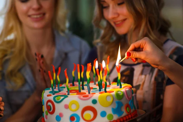 День народження. Дівчата запалюють свічки на торт — стокове фото
