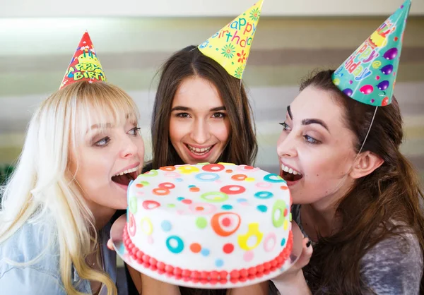 Születésnapi. Lányok harapás sütemény egy születésnapi partiján — Stock Fotó