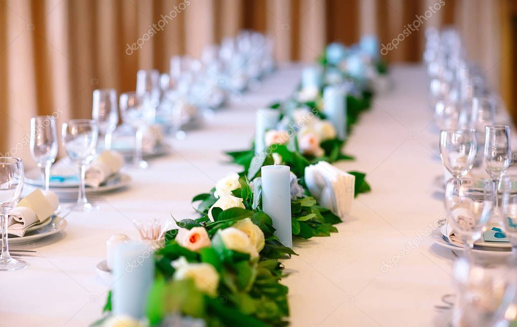 Wedding table settings. Empty plates and glasses on a white tablecloth.