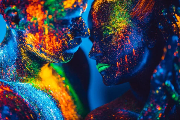 La gente es polvo fluorescente de color. un par de amantes bailando en una discoteca —  Fotos de Stock
