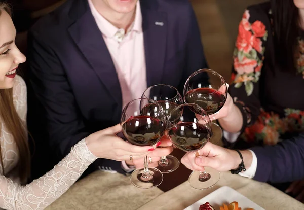 Amigos em um restaurante bebendo vinho tinto . — Fotografia de Stock