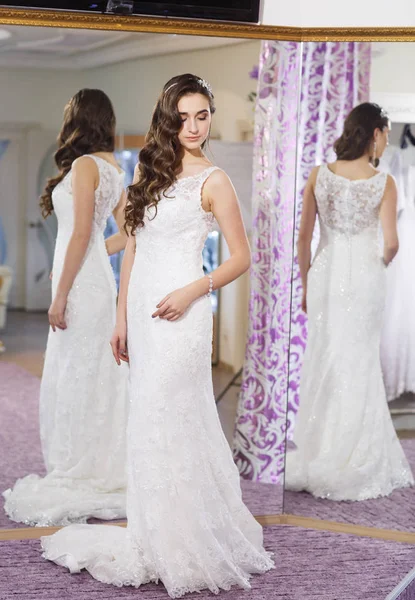 Frau probiert Hochzeitskleid im Geschäft an. — Stockfoto