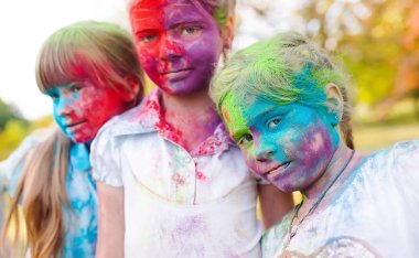 şirin Avrupa çocuk kız yüz ve vücut üzerinde renkli boya tozu ile Hint holi festival kutlamak