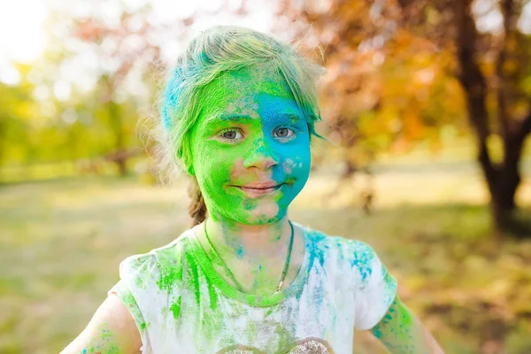 Portrait of a cute girl painted in the colors of Holi festival. — Stock Photo, Image