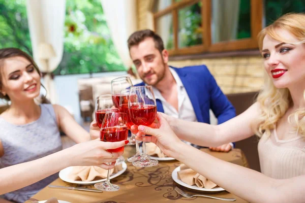 Друзі п'ють вино на літній терасі . — стокове фото