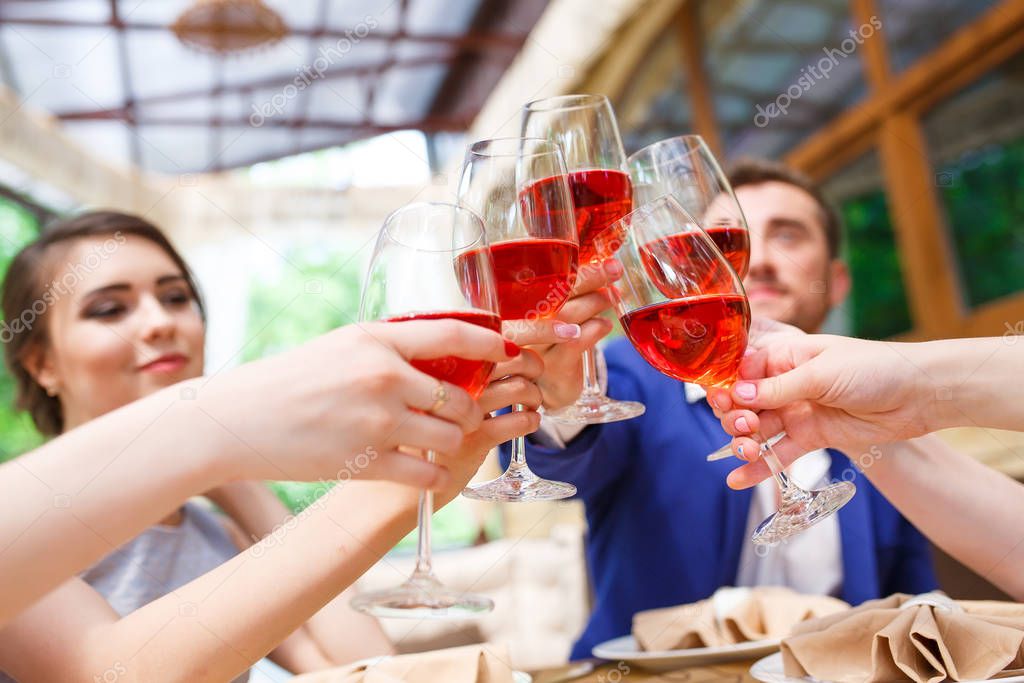 Friends drinking wine on the summer terrace.