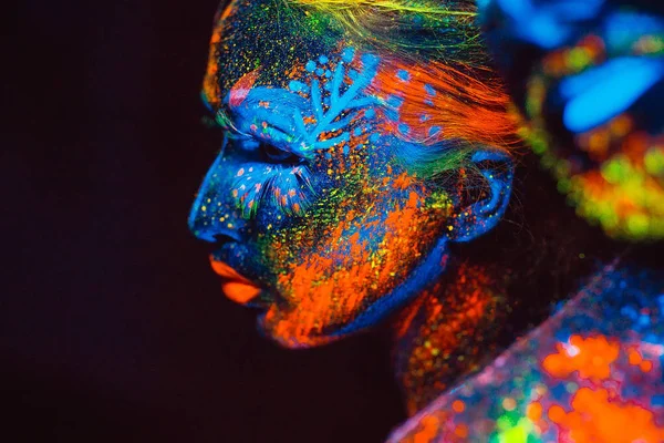 Retrato de un par de amantes pintados en polvo fluorescente . — Foto de Stock