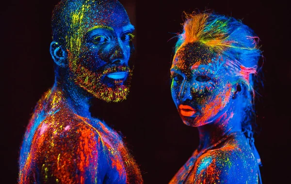 Retrato de un par de amantes pintados en polvo fluorescente . —  Fotos de Stock