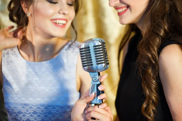 De meiden zingen Karaoke in het restaurant. — Stockfoto