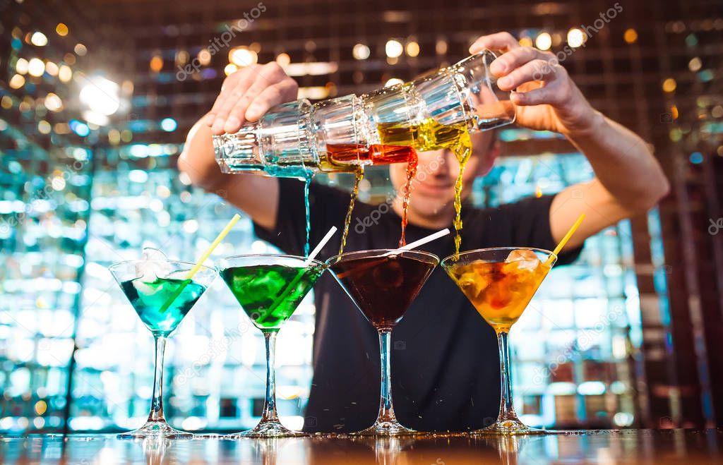 Barman show. Bartender pours alcoholic cocktails at the bar.